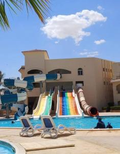 a pool with a water slide in a resort at شاليهات للايجار بالعين السخنه in Kafr Rāshid