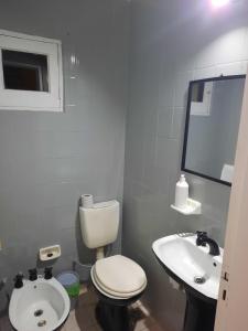 a white bathroom with a toilet and a sink at Duplex familiar zona macrocentro in Resistencia