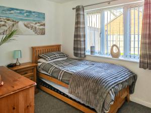 a bedroom with a bed and a window at Lilypots in Scratby +8 photos