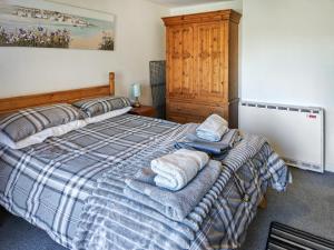 a bedroom with a bed with towels on it at Lilypots in Scratby