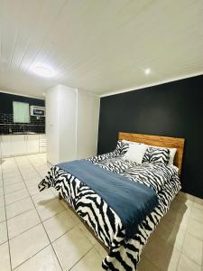 a bedroom with a zebra print bed with a black wall at Silwood Heights Flatlet in Eerste River in Faure
