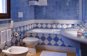 a blue and white bathroom with a toilet and a tub at Hotel Mare Blu Terme in Ischia