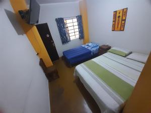 a small room with two beds and a window at Brabant Hostal in Nazca