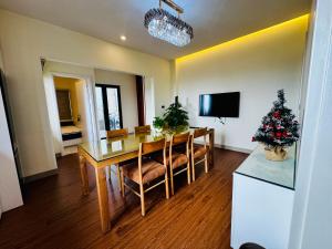 a dining room with a table and a christmas tree at May Home Hoalu in Phúc Trì