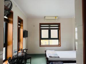 a small room with a bed and a window at Khách sạn AMI in Vinh