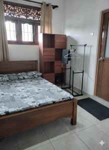 a bedroom with a wooden bed and a dresser at DenbyD in Tennekumbura