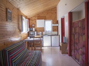 a small kitchen with a table and a dining room at Chalet avec terrasse - 4 pers. - API-1-52-2108 in Naucelle