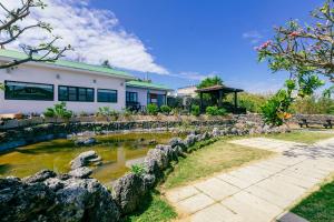 a house with a pond in front of it at 1302海景民宿 in Xiaoliuqiu