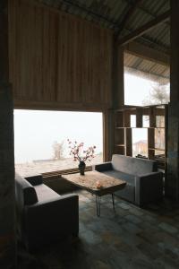 a living room with a couch and a table at Pơ Mu Mống Vàng in Bắc Yên