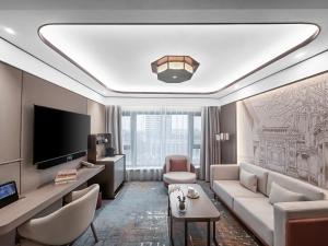 a living room with a couch and a tv at Beijing International Hotel in Beijing