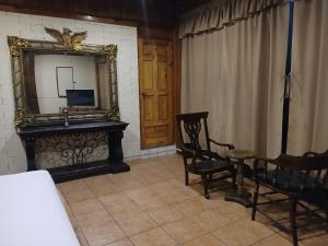 a room with a mirror and a table and chairs at Mansión Del Arco in San Pedro La Laguna