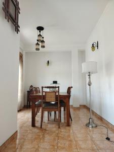 a dining room with a table and chairs and a lamp at DenbyD in Tennekumbura