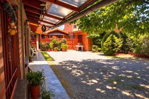 a patio of a house with a table and plants at Cabañas Tunquelen in El Bolsón