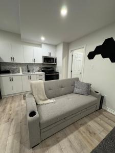 a living room with a couch and a kitchen at Spacious High Ceiling Lower Level Suite-New & Cozy in Vaughan +16 photos