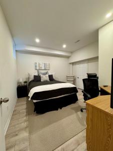 a bedroom with a bed and a chair in it at Spacious High Ceiling Lower Level Suite-New & Cozy in Vaughan