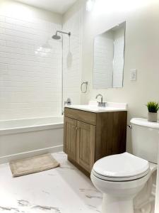 a bathroom with a toilet and a sink and a tub at Spacious High Ceiling Lower Level Suite-New & Cozy in Vaughan