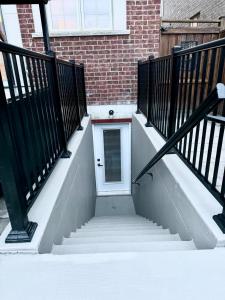 a stairway with a white door and a brick building at Spacious High Ceiling Lower Level Suite-New & Cozy in Vaughan