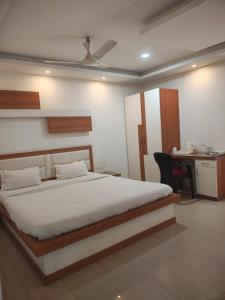 a bedroom with a bed and a desk with a chair at Hotel Jyoti Sanjay in Pūrnia +14 photos
