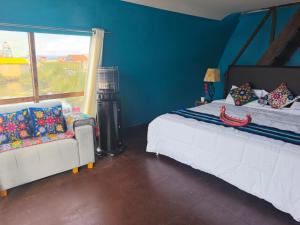 a bedroom with two beds and a couch and a window at Suma Kusi en el Titicaca in Puno