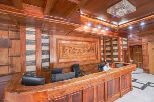 a man sitting at a bar in a room with wooden walls at Phetchalern serviced apartment in Vientiane