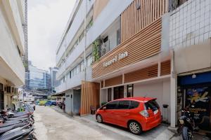 a small red car parked in front of a building at Laurel Inn Menteng in Jakarta