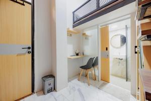 a small room with a chair and a bathroom at Laurel Inn Menteng in Jakarta