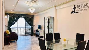 a dining room with a glass table and chairs at Glory Beach Resort By D'Shepherd Management in Port Dickson