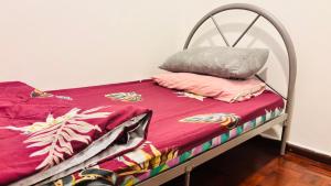 a bed with a metal frame with two pillows on it at Glory Beach Resort By D'Shepherd Management in Port Dickson