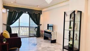 a living room with a large window and a chair at Glory Beach Resort By D'Shepherd Management in Port Dickson