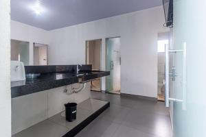 a bathroom with a black counter and a sink at Apartamento para 6 com Vaga e Churrasqueira in Pará de Minas