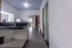 a kitchen with a sink and a long hallway at Apartamento para 6 com Vaga e Churrasqueira in Pará de Minas