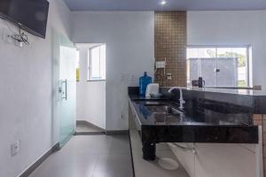 a large bathroom with a sink in a room at Apartamento para 6 com Vaga e Churrasqueira in Pará de Minas