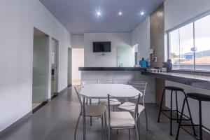a kitchen with a table and chairs in a room at Apartamento para 6 com Vaga e Churrasqueira in Pará de Minas +15 photos