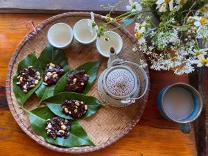 a wooden table with a plate of food and a cup of coffee at Mộc Lan’s House in Phi Liêng