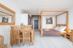 a bedroom with a bed and a table and chairs at Orient Bay Studio SABA Face à la Mer in Cul de Sac +40 photos