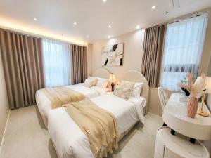 a bedroom with two beds and a table and a desk at 4rest Stay Jongno in Seoul