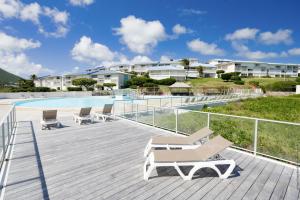 a deck with lounge chairs and a swimming pool at Orient Bay Studio SABA Face à la Mer in Cul de Sac