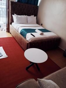 a bed in a room with a table and a stool at Jipso homes in Eldoret