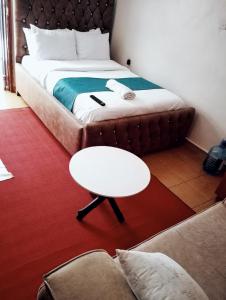 a room with a bed and a table and a couch at Jipso homes in Eldoret