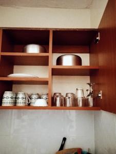 a kitchen with wooden shelves with pots and pans at Jipso homes in Eldoret