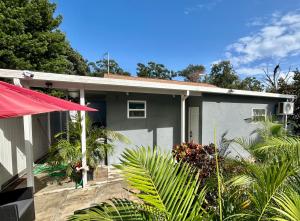 a gray house with a red umbrella in front of it at Suite Villa Roman in Tampa