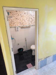 a bathroom with a toilet and a shower and a doorway at Ao Siri Beach Bungalow in Ko Jum