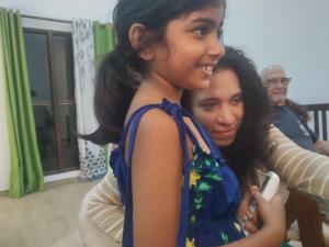 a young girl standing next to a woman holding a cell phone at ADOBE AFFECTIOn in Tangalle