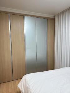 a bedroom with a white bed and wooden cabinets at Hi Seoul Gongdeok 2 in Seoul