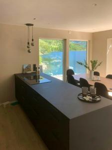 a kitchen with a large island with a view of the water at Newly Built Cabin With Sauna By Oldevatnet in Olden