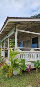 a wooden house with a porch and some plants at Pondok Satu Hati Sidemen in Sidemen
