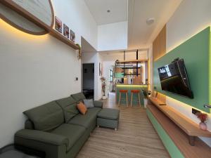 a living room with a couch and a flat screen tv at Pendo Mansion in Pulau Sembakau Kecil