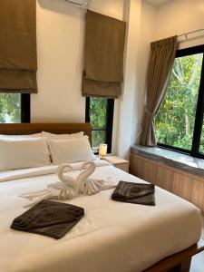 a bedroom with a bed with two swans on it at Rancho Relaxo Pool Villa in Nathon Bay