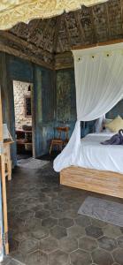 a bedroom with a bed with a canopy at Pondok Satu Hati Sidemen in Sidemen