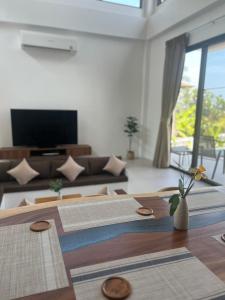 a living room with a couch and a table at Rancho Relaxo Pool Villa in Nathon Bay +20 photos